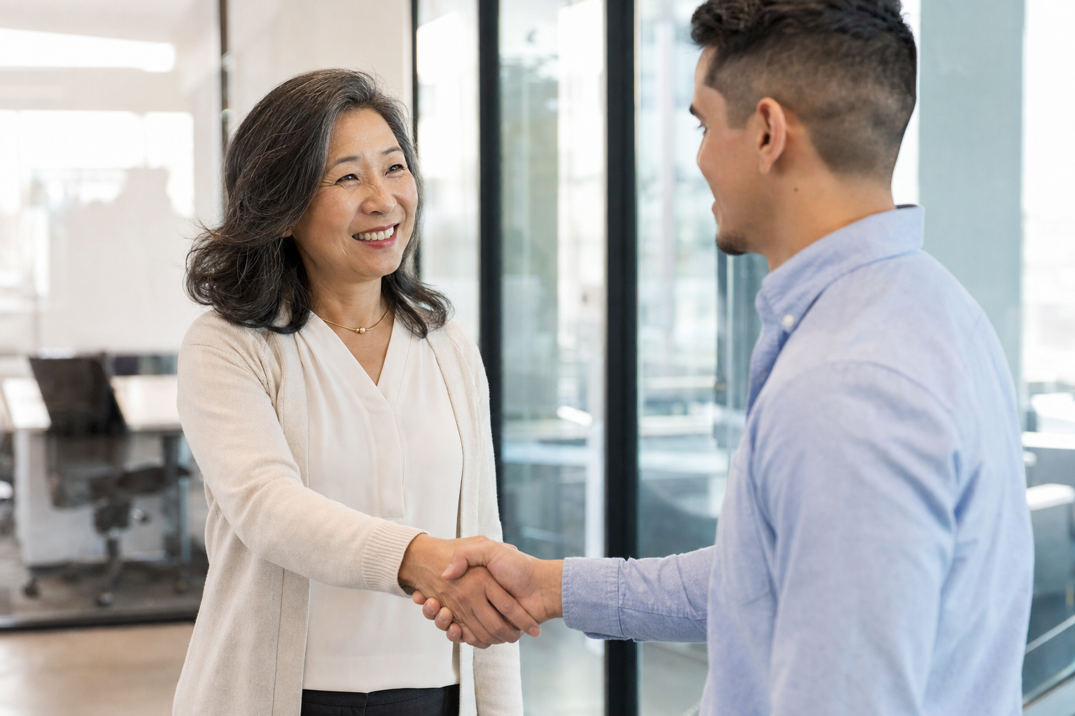 New hire being welcomed with a handshake in an office